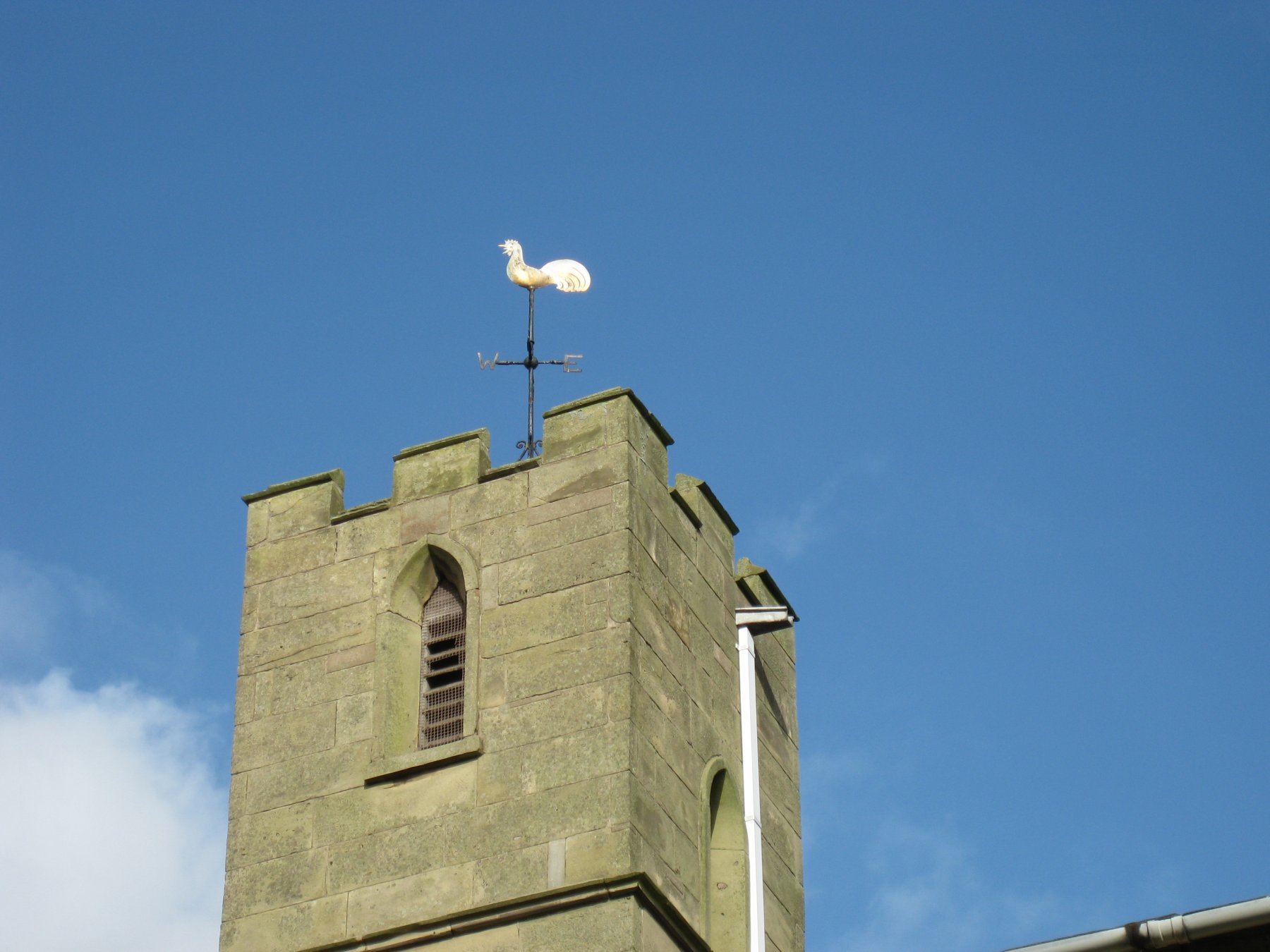 a church tower with a cockerel weather vane on top